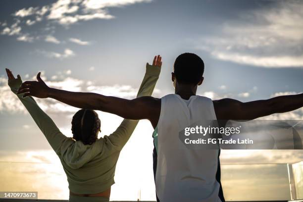 couple with arms outstretched enjoying the morning - challenger tour 2 stock pictures, royalty-free photos & images