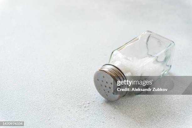 a new clean wooden spatula, a kitchen towel and a salt shaker on the dining table. the concept of cooking in a restaurant and cafe, at home in the kitchen. cook it yourself, taking courses on the ability to cook delicious and beautiful food. copy space. - salt shaker stockfoto's en -beelden