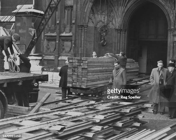 Lengths of wood on specially laid rails as preparations are made to lay a temporary wooden floor in the nave for the Coronation of Elizabeth II at...