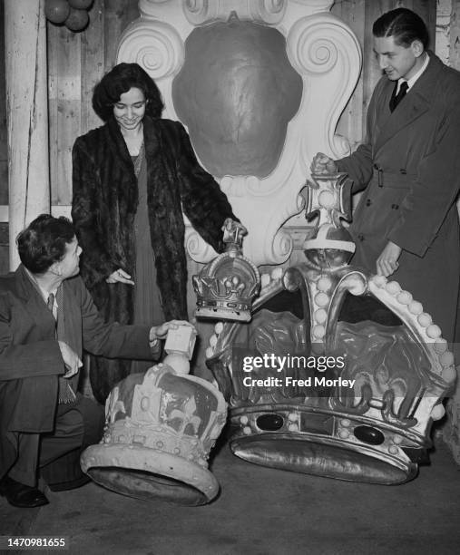 Visitors inspect the decorations which will decorate every town and village during the celebrations for the Coronation of Elizabeth II, at an flag...