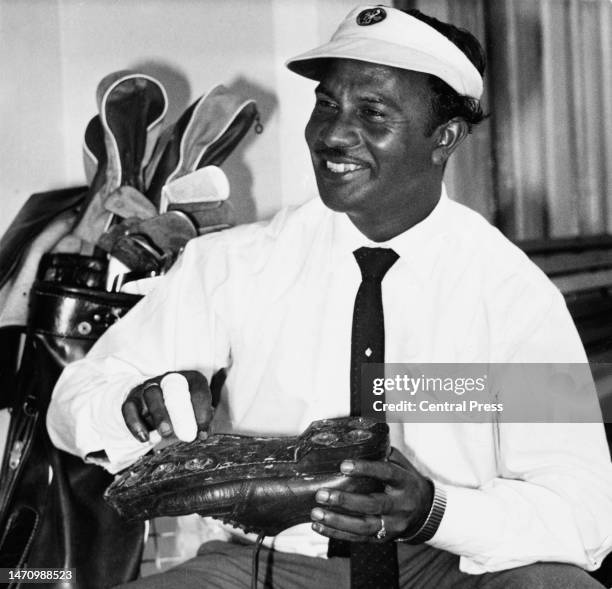 Portrait of Sewsunker "Papwa" Sewgolum from South Africa of ethnic Indian cleans his golf shoes before competing in the 1961 South African Open Golf...