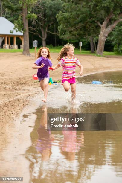 girls playing at beach on summer day - lakeshore park stock pictures, royalty-free photos & images