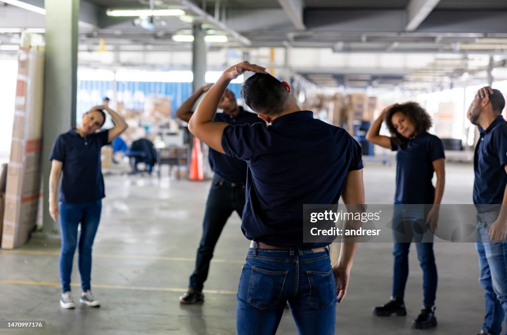 Group of workers stretching on an active pause while working at a warehouse