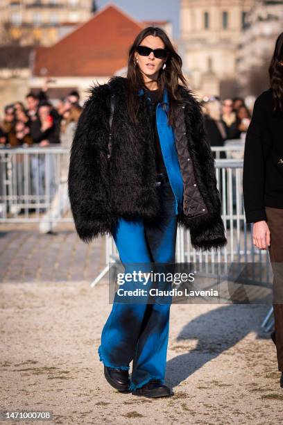 Vittoria Ceretti wears a black top, blue and black pants and black fur jacket, outside Givenchy, during Paris Fashion Week - Womenswear Fall Winter...