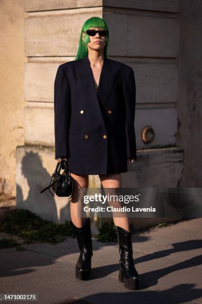 Alyy Space wears a dark blue Dior blazer, black boots, black bag and sunglasses, outside Givenchy, during Paris Fashion Week - Womenswear Fall Winter...