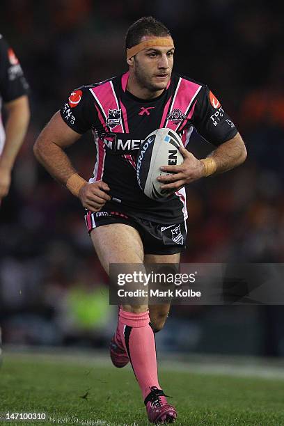 Robbie Farah of the Tigers runs the ball during the round 16 NRL match between the Newcastle Knights and the Wests Tigers at Hunter Stadium on June...