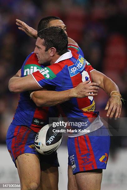 Timana Tahu of the Knights is congratulated by Danny Buderus of the Knights after scoring a try during the round 16 NRL match between the Newcastle...