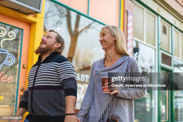 millennial couple outdoors in small town america having coffee and pastries photo series - amerikaans dorpsleven stockfoto's en -beelden