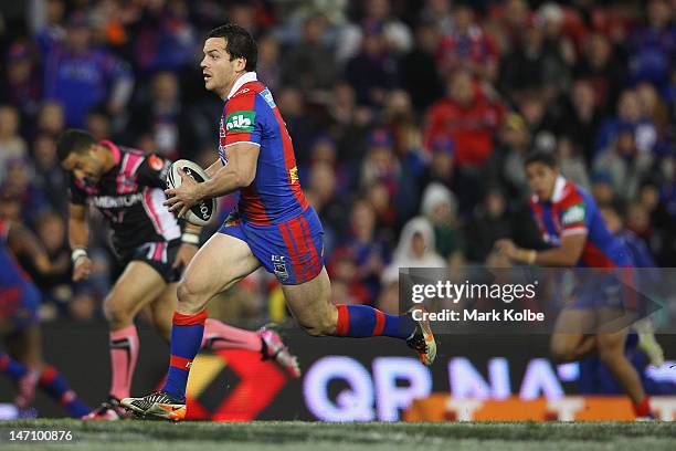 Jarrod Mullen of thje Knights makes a break during the round 16 NRL match between the Newcastle Knights and the Wests Tigers at Hunter Stadium on...