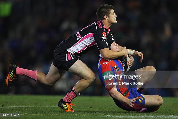 Blake Ayshford of the Tigers tackles Joel Edwards of the Knights during the round 16 NRL match between the Newcastle Knights and the Wests Tigers at...