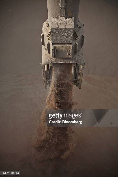 Grain pours into a storage chamber onboard the "African Wind" cargo ship, moored at Lecureur SA's cereal plant, on the banks of the River Seine in...