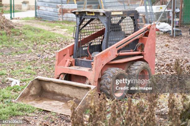 skid steer with empty seat parked on the ground in some field, no people in side view - land clearing stock pictures, royalty-free photos & images