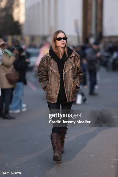 Pernille Teisbaek seen wearing brown Miu Miu leather boots, a matching brown oversized leather jacket, a black sweater, black leggings and black...