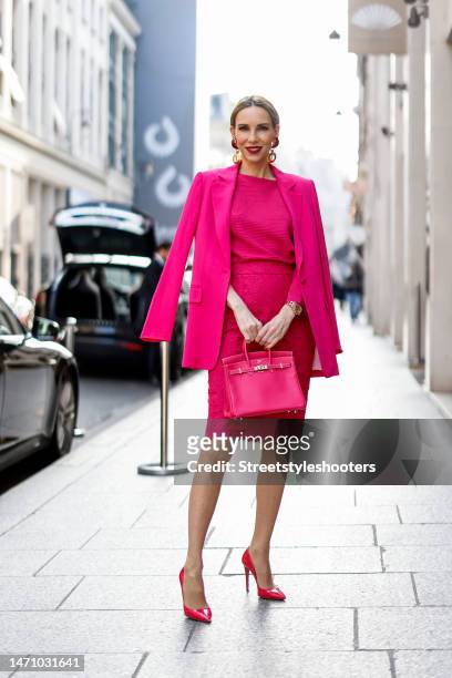 Alexandra Lapp is seen wearing MADELEINE blazer in pink, MADELEINE knit jumper in pink, MADELEINE lace skirt in pink, and PRADA pumps in pink and...