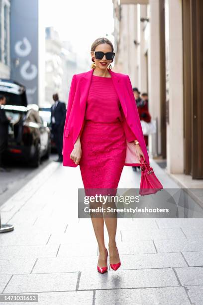 Alexandra Lapp is seen wearing MADELEINE blazer in pink, MADELEINE knit jumper in pink, MADELEINE lace skirt in pink, and PRADA pumps in pink and...