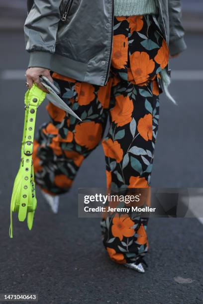 Fashion week guest seen wearing a neon green Balenciaga le cagole leather bag, a bomber jacket, a light blue knit balaclava, with a matching knit...