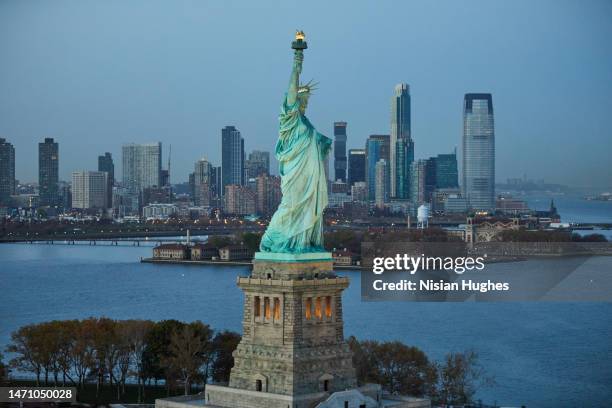 aerial photo of the statue of liberty in new york city at sunset - new york liberty center stock pictures, royalty-free photos & images