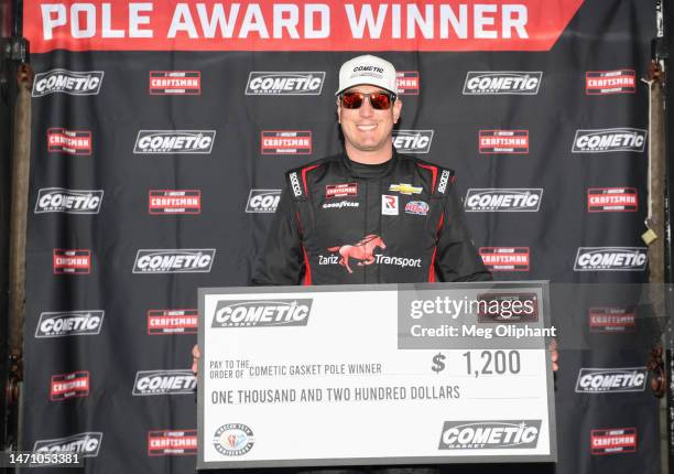 Kyle Busch, driver of the Zariz Transport Chevrolet, poses with the pole award winner $1,200.00 check during qualifying for the NASCAR CRAFTSMAN...