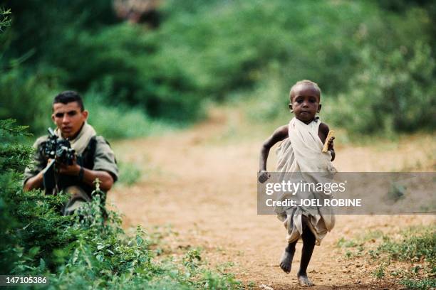 Photo dated 17 December 1992 shows a Somali boy running towards a relief convoy as it arrives in a village 25km northwest of Baidoa as a French...