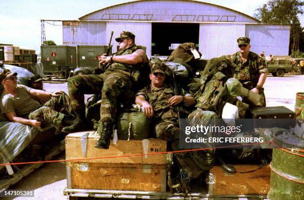 Group of U.S. Marines takes a break in the sun after unloading their equipment at Mogadishu airport 11 December 1992 to take part in "Operation...