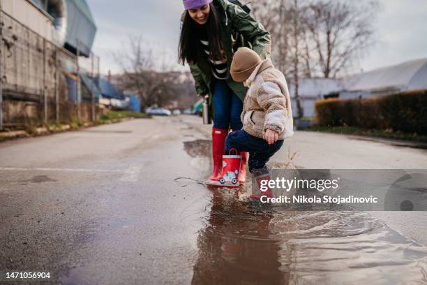 días de lluvia con mi mamá - charco fotografías e imágenes de stock