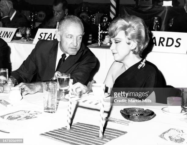 American comedienne, actress, singer and businesswoman Edie Adams sits with an unidentified man while attending the NFL Hall Of Fame Weekend dinner...
