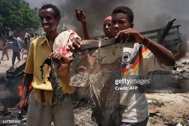 Somalis hold a pair of camouflage trousers, 03 October 1993 in a Mogadishu street, claimed to be from a U.S. Soldier killed during clashes with...
