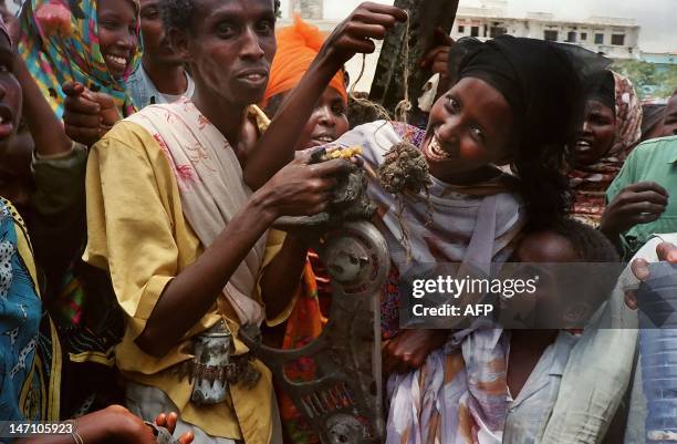 Somalis pose in a Mogadishu street, 04 October 1993, with what they claim to be the remains of a U.S. Soldier killed 03 October during a battle with...