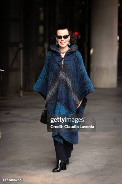 Debi Mazar wears a blue and grey cape, black pants and black boots, outside Chloe, during Paris Fashion Week - Womenswear Fall Winter 2023 2024, on...