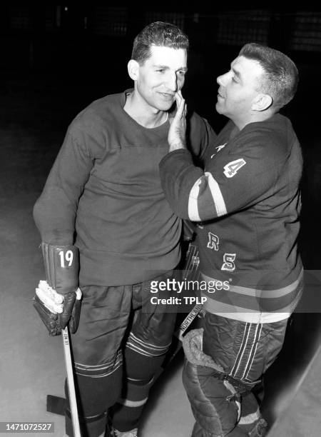 Goalie Gump Worsley of the New York Rangers looks at the black eye of his teammate Larry Popein during practice at Madison Square Garden in New York,...