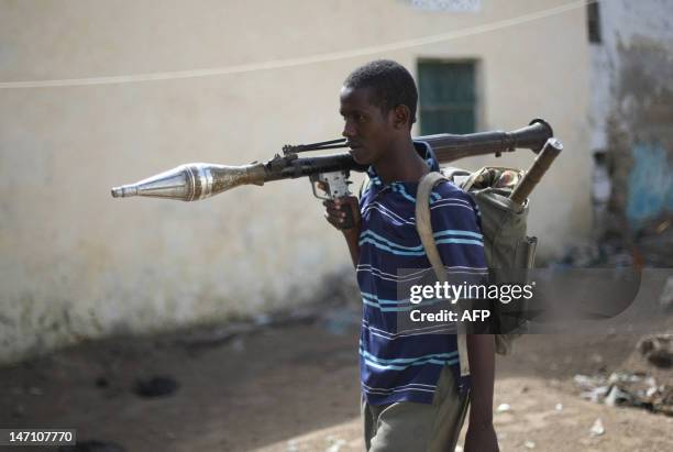 An Al-Shabab Islamic fighter, wearing a rock launcher, walk at a front line section in sanca district in Mogadishu on July 21, 2009. Somalia's hard...