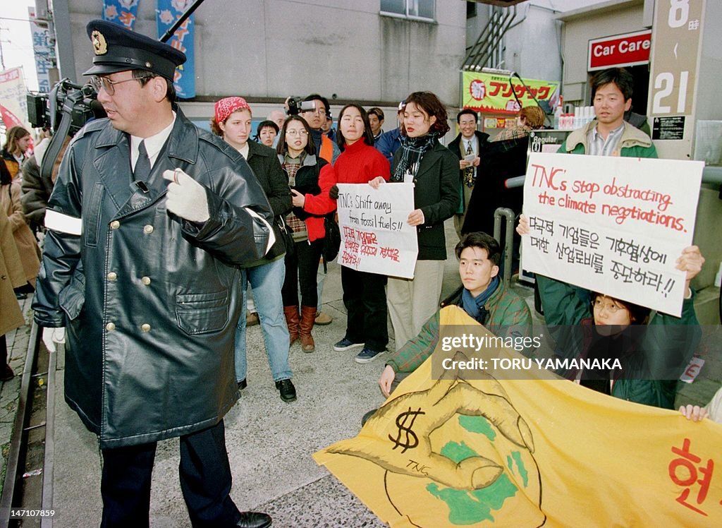 A Japanese policeman (L) looks on as env