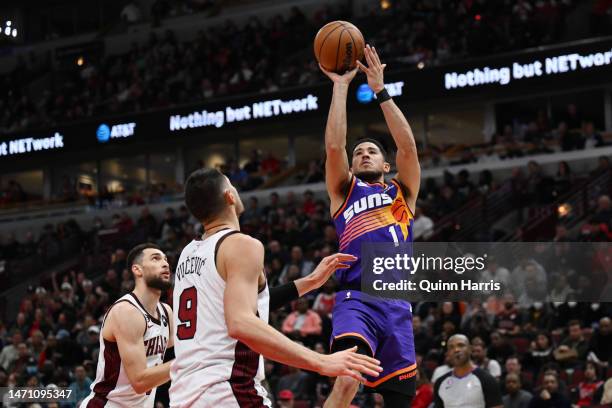 Devin Booker of the Phoenix Suns shoots in the second half against Zach LaVine of the Chicago Bulls at United Center on March 03, 2023 in Chicago,...