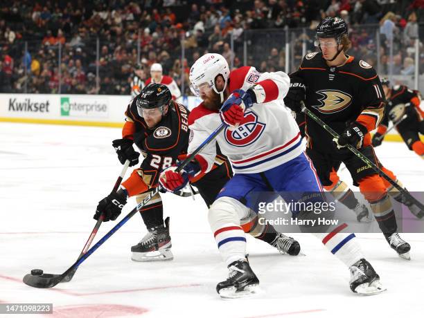 Nathan Beaulieu of the Anaheim Ducks clears the puck from David Savard of the Montreal Canadiens as Trevor Zegras looks on during the first period at...