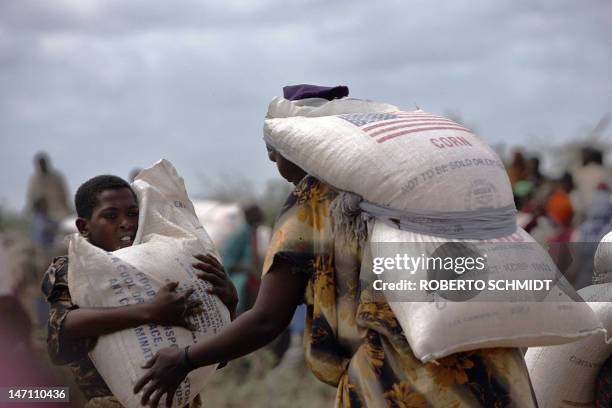 Somali boy tries his best to lift a 100kg sac of food aid distributed by the United Nations World Food Program to displaced Somalis in the Kalagay...