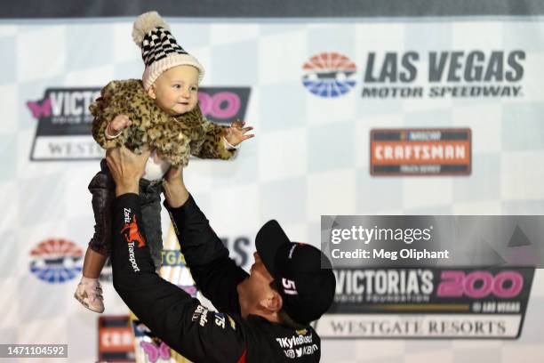 Kyle Busch, driver of the Zariz Transport Chevrolet, celebrates with his daughter, Lennix Key in victory lane after winning to the NASCAR CRAFTSMAN...