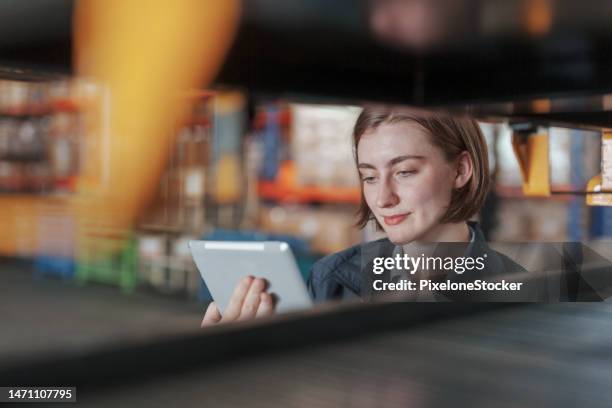 female worker using tablet working in a distribution warehouse. - loading bay stock pictures, royalty-free photos & images