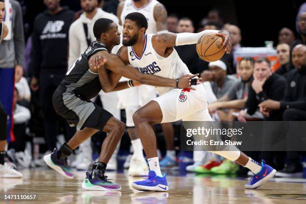 Paul George of the LA Clippers is guarded by De'Aaron Fox of the Sacramento Kings at Golden 1 Center on March 03, 2023 in Sacramento, California....