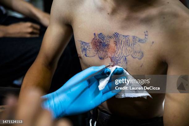 Devotee is given a tiger tattoo during the Wai Kru Festival at Wat Bang Phra on March 04, 2023 in Nakhon Pathom, Thailand. Each year thousands of...