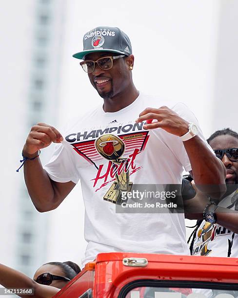 Dwyane Wade of the Miami Heat shows off his championship t-shirt as he rides in a victory parade through the streets during a celebration for the...