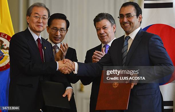 South Korean Trade Minister Bark Tae-ho and his Colombian counterpart Sergio Diaz Granados shake hands after the signing of a Free Trade Agreement...