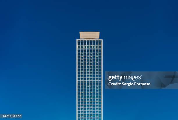 isolated skyscraper against blue sky - straßenschlucht stock-fotos und bilder