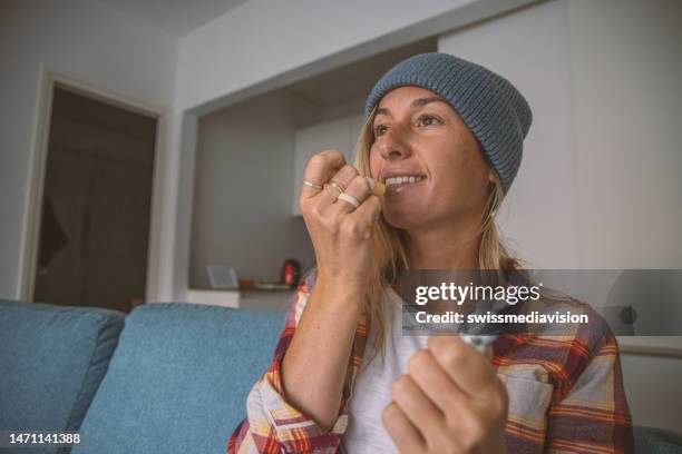 woman using cbd lipstick on her lips - dry lips stock pictures, royalty-free photos & images