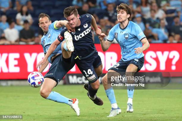 Connor Chapman of the Victory dives for a header under pressure from Alex Wilkinson of Sydney FC during the round 19 A-League Men's match between...