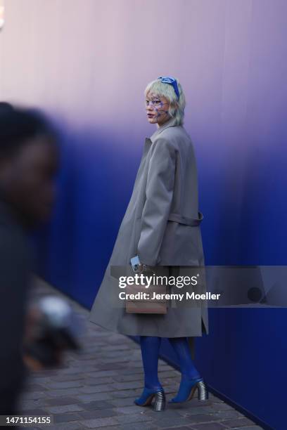 Kicki Yang Zhang seen wearing a grey long coat, rose leather handbag, blue leather boots and blue sunglasses outside Off White, during Pariser...