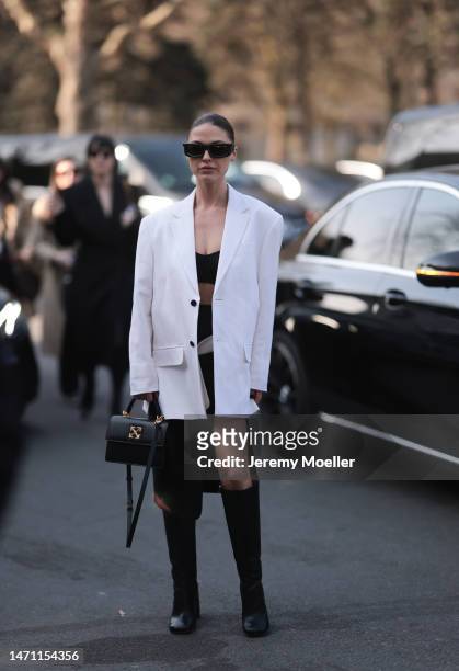 Sophia Roe seen wearing a white oversized blazer, black long skirt, top and black boots and a black leather Off White bag and sunglasses outside Off...