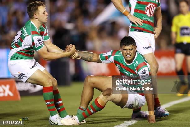 Blake Taaffe of the Rabbitohs helps Latrell Mitchell of the Rabbitohs to his feet during the round one NRL match between Cronulla Sharks and South...