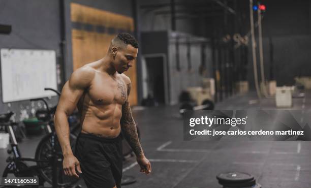 man walking in gym, shirtless tattooed weightlifter - macho photos et images de collection