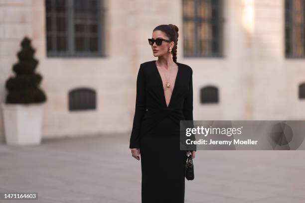 Füsun Lindner seen wearing Celine black sunglasses, Maison Ju black v-neck long dress with long sleeves, Ole Lynggaard gold elephant pendant necklace...