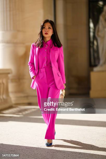 May Berthelot wears diamonds earrings, a neon pink shirt from Theory, a matching neon pink blazer jacket, matching neon pink suit pants, silver chain...